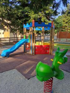 a playground with a green dinosaur on a slide at A casa di zia Maly in Palena