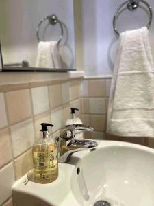 a bathroom sink with a soap dispenser on it at City Mill - Next to Town Centre Shopping and Restaurants - Free Parking in Burton upon Trent