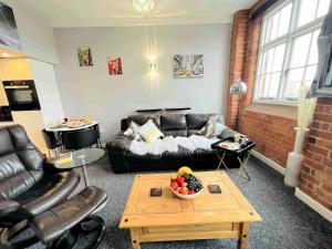 a living room with a couch and a table at City Mill - Next to Town Centre Shopping and Restaurants - Free Parking in Burton upon Trent