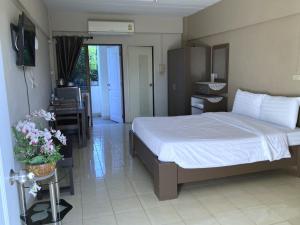 a bedroom with a bed and a desk with a chair at Hotel M Rojana Ayutthaya in Ban Sang