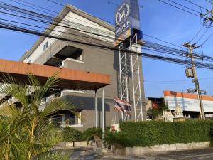 a building with a clock on the side of it at Hotel M Rojana Ayutthaya in Ban Sang