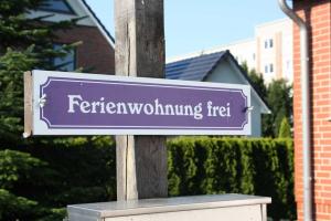 a purple street sign on a wooden pole at Ferienwohnung Ackermann in Ribnitz-Damgarten