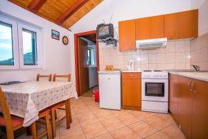 a kitchen with a table and a small kitchen with a stove and a microwave at House Country in Gata