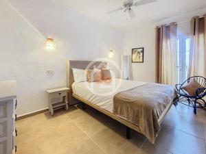 a bedroom with a bed and a chair in it at Apartamento Berdica in Benitachell