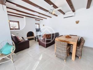 a living room with a table and chairs and a fireplace at Apartamento Berdica in Benitachell