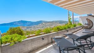 a balcony with chairs and a view of the ocean at villa vinka in Kalkan