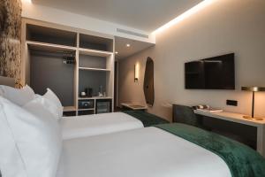 a hotel room with a large white bed and a desk at Dolinas Climbing Hotel in Porto de Mós +33 photos