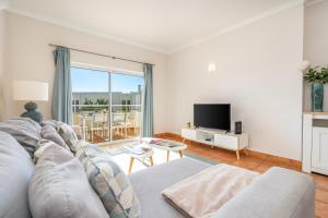 a living room with a couch and a tv at Host Wise - Bright & Stylish Lagos Flat with Pool in Lagos