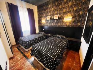 a room with two beds and a window at Alhambra Suites in Madrid