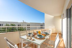 a dining room with a table and chairs on a balcony at Host Wise - Bright & Stylish Lagos Flat with Pool in Lagos