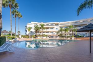 a resort pool with palm trees and a building at Host Wise - Bright & Stylish Lagos Flat with Pool in Lagos