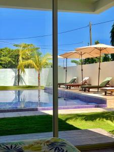 a view of a pool with two tables and umbrellas at Villa Roman Marino VIP in El Conacaste