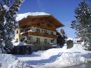 ein großes Haus mit Schnee seitlich in der Unterkunft Gästehaus Rosa Leitgeb in Faistenau