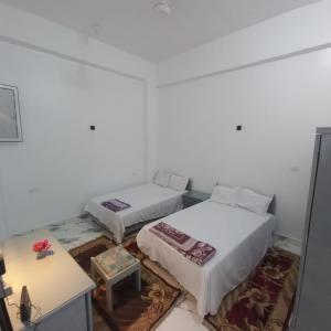 a room with two beds and a table at Nora House in Luxor