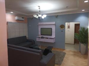a living room with a couch and a tv at 2 Bedroom Cute Cozy Hideaway in Ikeja
