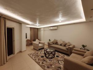 a living room with couches and a rug at طيبة جاردنز أكتوبر in 6th Of October