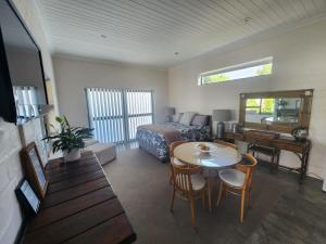 a bedroom with a bed and a table and a desk at Anthony Accommodation in Stilbaai