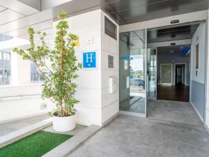 una entrada a un edificio de oficinas con una maceta en Ibis Budget Madrid Vallecas, en Madrid