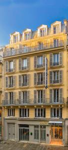 a large yellow building with a lot of windows at Hôtel de Roubaix in Paris