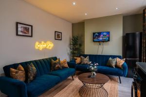 a living room with a blue couch and a table at Contractor-Friendly 3-Bed, Games Room, Pool Table! in Enfield Lock