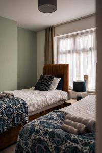 a bedroom with two beds and a window at Contractor-Friendly 3-Bed, Games Room, Pool Table! in Enfield Lock