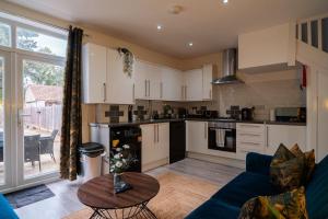 a kitchen and living room with a blue couch and a table at Contractor-Friendly 3-Bed, Games Room, Pool Table! in Enfield Lock