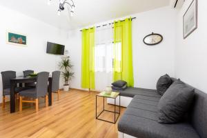 a living room with a couch and a dining table at Apartman Zvjezdana in Krk