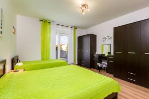 a bedroom with two green beds and a desk at Apartman Zvjezdana in Krk