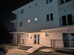 a large white building with stairs leading to a door at Apartman Viktor in Surčin