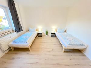 a room with two beds and a window at III Apartment für bis zu 6 Personen, 94431 Großköllnbach in Pilsting