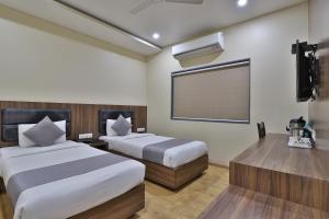 Postel nebo postele na pokoji v ubytování Hotel Limra Vadodara