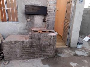 a brick fireplace in the corner of a building at Casa da rafaa in Itanhaém
