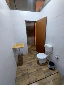 a bathroom with a toilet and a sink at Casa da rafaa in Itanhaém +5 photos