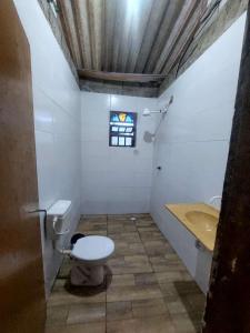 a bathroom with a toilet and a sink at Casa da rafaa in Itanhaém