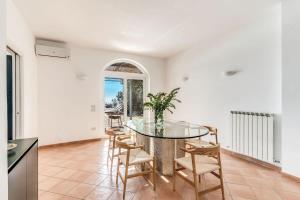 a dining room with a glass table and chairs at Villa Chez Piè Panoramic Views Pool and Guest Services in SantʼAgata sui Due Golfi