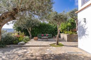 a patio with a couch and a table and trees at Villa Chez Piè Panoramic Views Pool and Guest Services in SantʼAgata sui Due Golfi