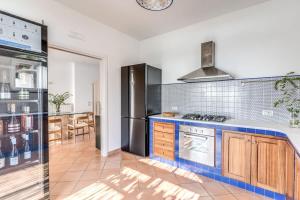 a kitchen with a stove and a refrigerator at Villa Chez Piè Panoramic Views Pool and Guest Services in SantʼAgata sui Due Golfi