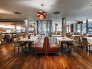 a restaurant with wooden floors and tables and chairs at Hotel Balnea Superior - Terme Krka in Dolenjske Toplice