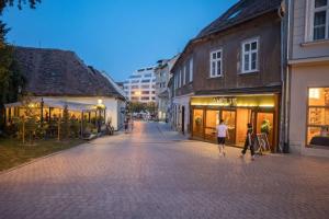 two people walking down a street in a city at Apartment Kaptol in Zagreb