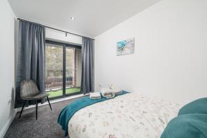 ロンドンにある3 bed home by Canning Town stationのベッドと椅子と窓のある寝室