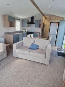 a living room with a couch and a kitchen at Cresswell Towers in Morpeth