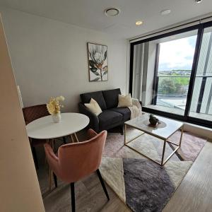 una sala de estar con un sofá y una mesa en Urban Oasis - Spa, Pool and Kitchen, en Auckland