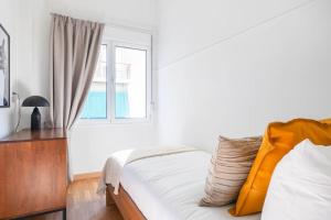 a white bedroom with a bed and a window at Modern Apt opposite the Acropolis Museum in Athens +8 photos