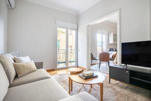 a living room with a couch and a flat screen tv at Modern Apt opposite the Acropolis Museum in Athens