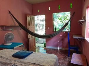 ein Schlafzimmer mit einer Hängematte in der Mitte eines Zimmers in der Unterkunft Caminho das pedras-Medicina, Consciência e espiritualidade- Hospedaria na floresta com saída ao Igarapé in Alter do Chao