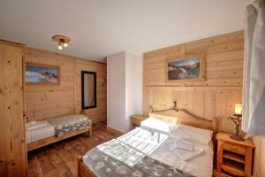 a bedroom with wooden walls and a bed in it at Chalet MontBlanc in La Plagne Tarentaise