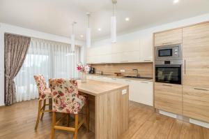 a kitchen with a wooden counter and a table with chairs at Villa Mala Halu in Katun Gračanski