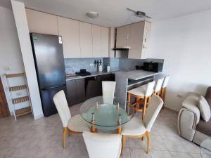 a kitchen with a glass table and chairs in a room at Sun Coast Apartment in Sveti Vlas