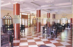 a room with tables and chairs on a checkered floor at Chettinaadu Narayana Vilas in Kānādukāttān