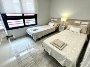 a bedroom with two beds and a window at Exclusive Apartments on the first line of Benidorm Mar y Sol in Benidorm +42 photos